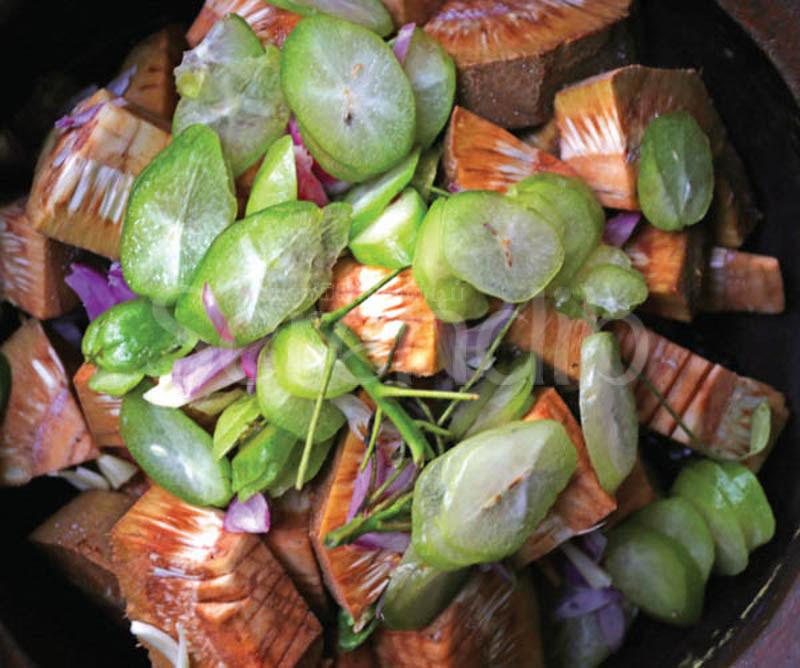 An uncooked jak fruit dish with biling fruits to add flavour to the curry