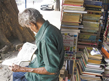 A bookshop owner peruses a pictorial book