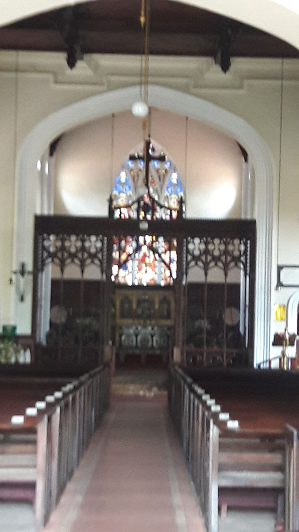 Interior of the Church with the stained glass window in the backdrop