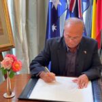 Photo of Anton Swan OAM JP (Qual) Hon. Consul General for Sri Lanka in Queensland writing a Condolence Message to the Royal Family on behalf the Diplomatic and Consular Corps of Qld. and the Sri Lankan community in Brisbane Qld. at Government House Brisbane.