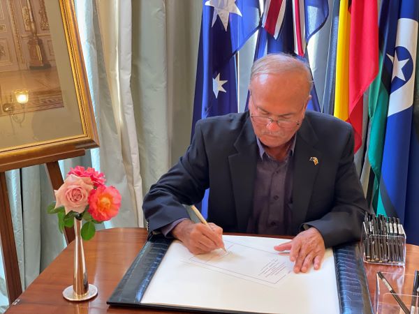Photo of Anton Swan OAM JP (Qual) Hon. Consul General for Sri Lanka in Queensland writing a Condolence Message to the Royal Family on behalf the Diplomatic and Consular Corps of Qld. and the Sri Lankan community in Brisbane Qld. at Government House Brisbane.