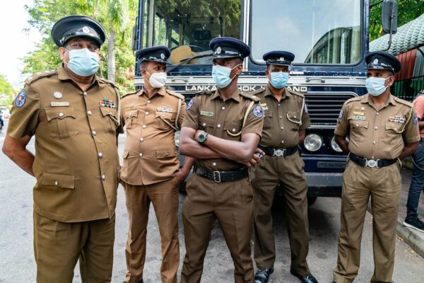 Police wait outside a Colombo courtroom where protesters are having their cases heard.