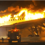 Looking beyond the burning aircraft at Haneda - By GEORGE BRAINE