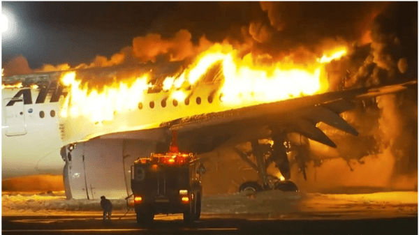 Looking beyond the burning aircraft at Haneda - By GEORGE BRAINE